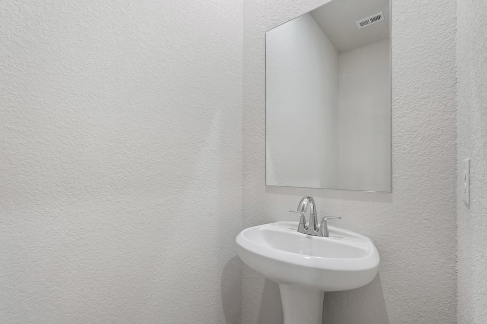 A bathroom with a mirror and sink.