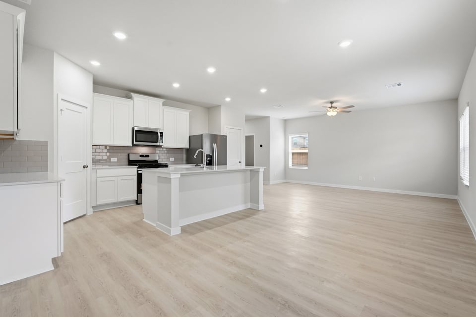 A kitchen with white cabinets.