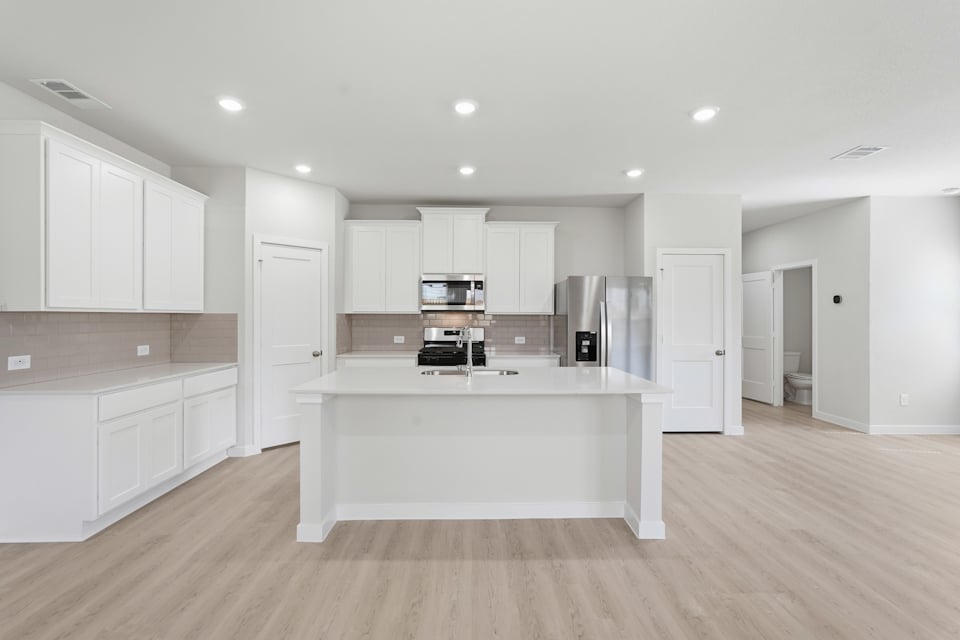 A kitchen with white cabinets.