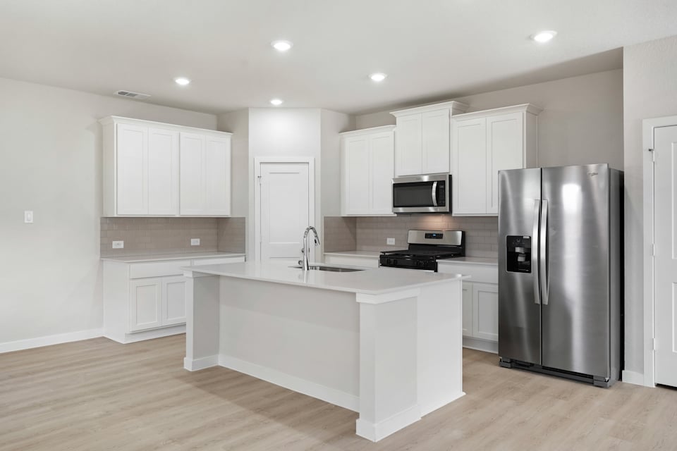 A kitchen with white cabinets.