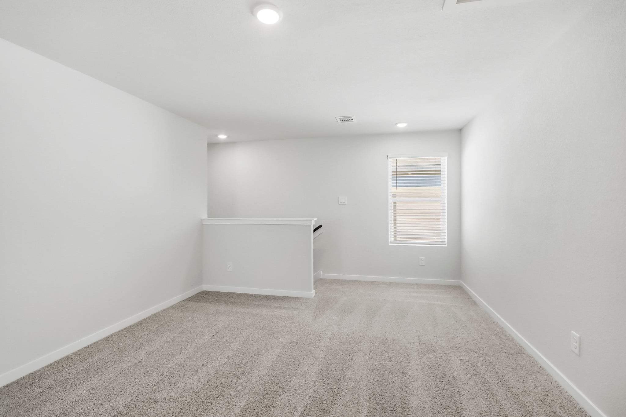 A room with a white wall and a window.