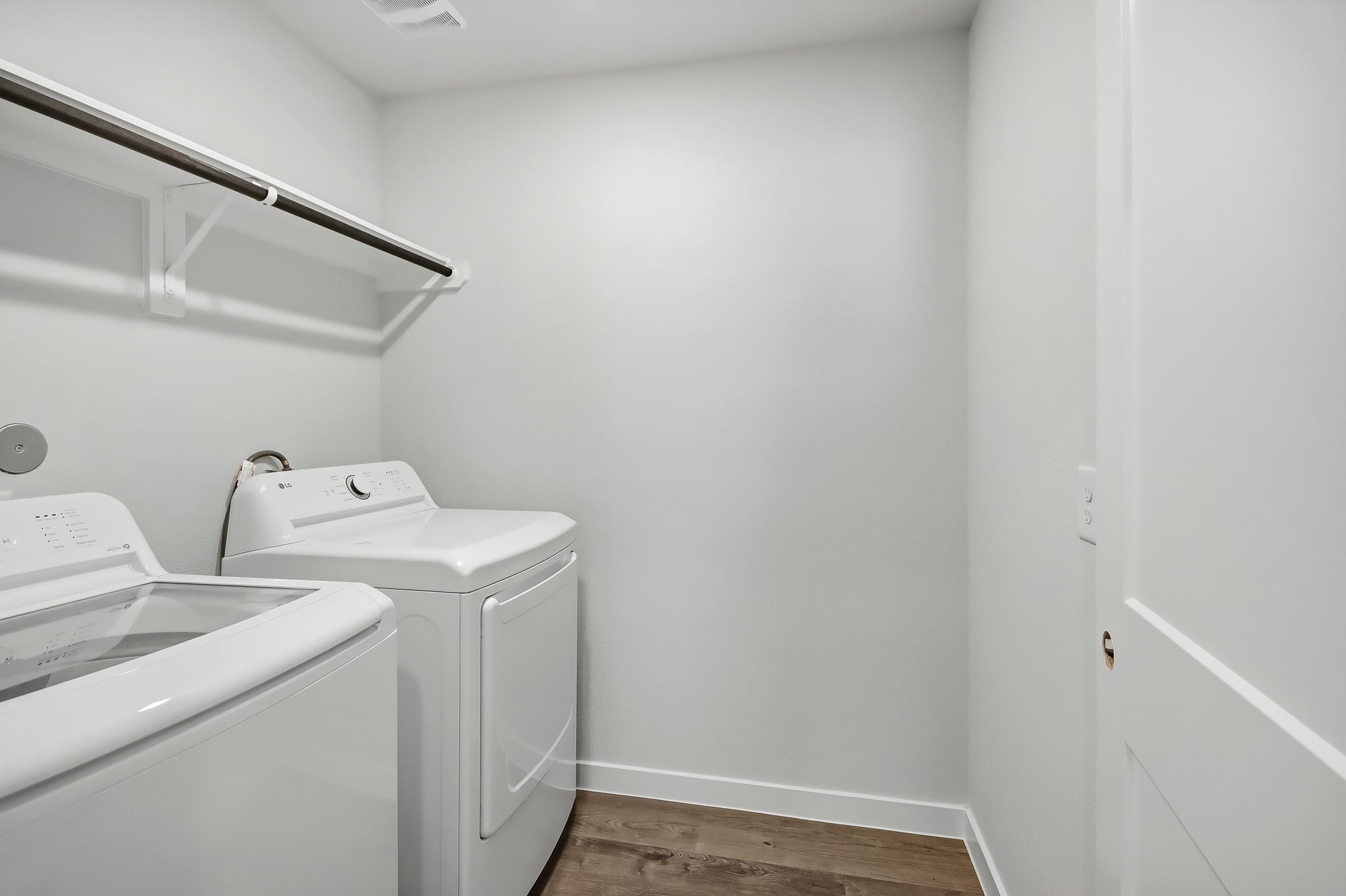 A room with a washing machine and a sink.