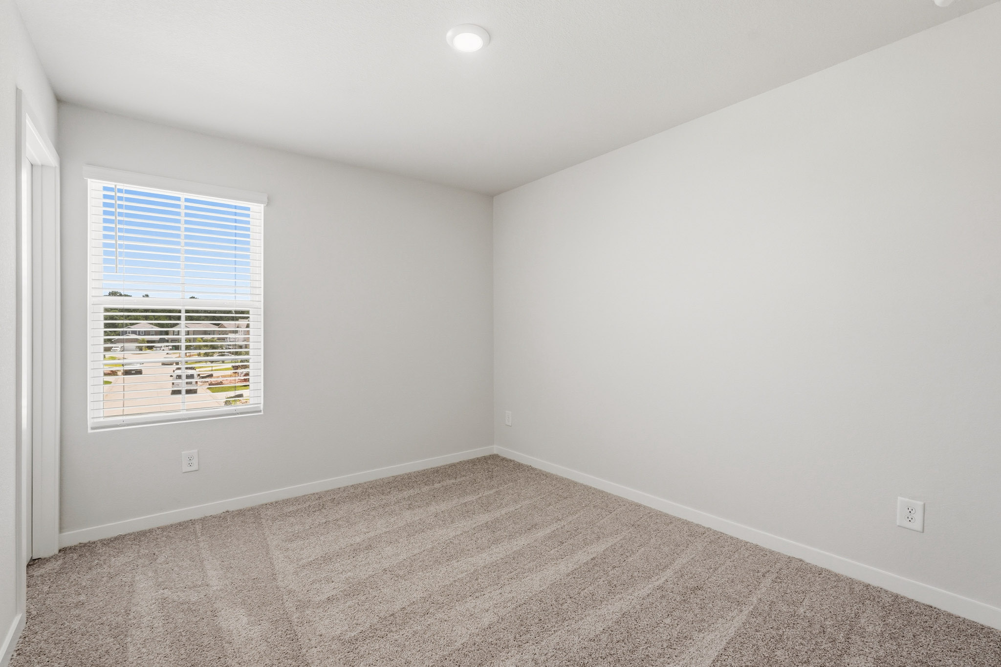 A room with a window and a carpet.