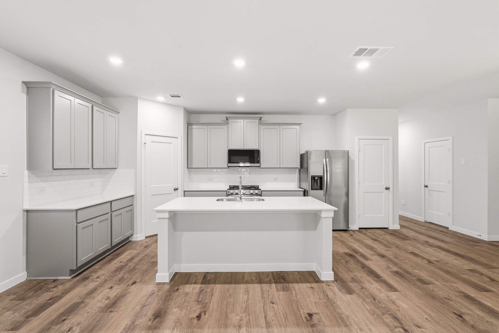A kitchen with white cabinets.