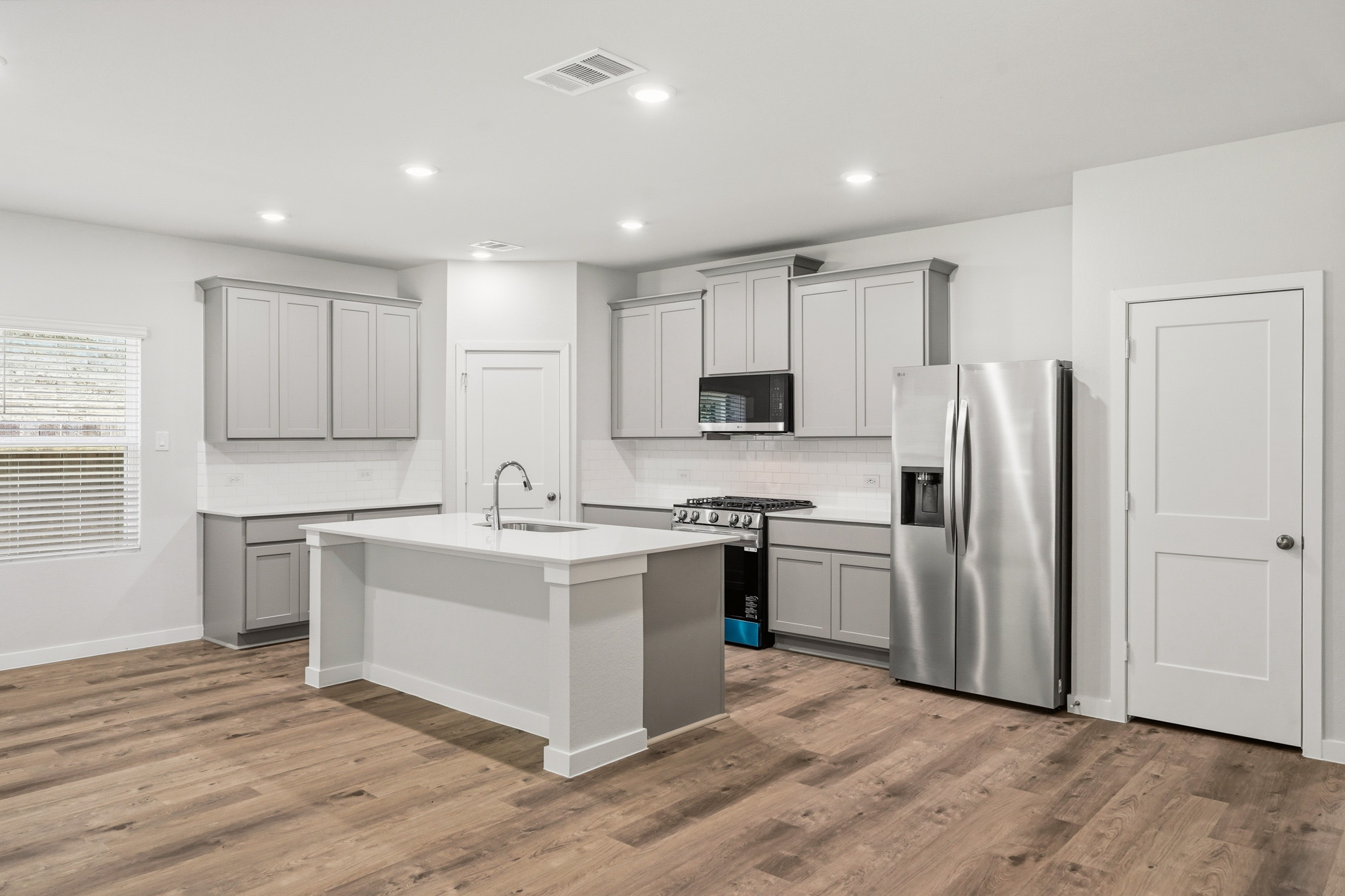 A kitchen with white cabinets.