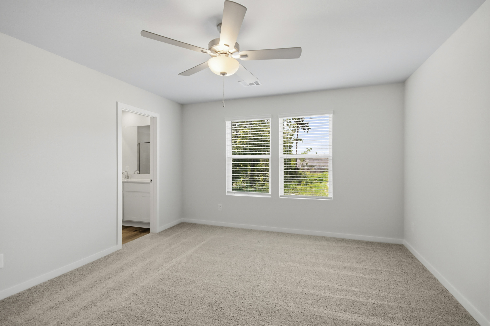 A room with a ceiling fan and a window.