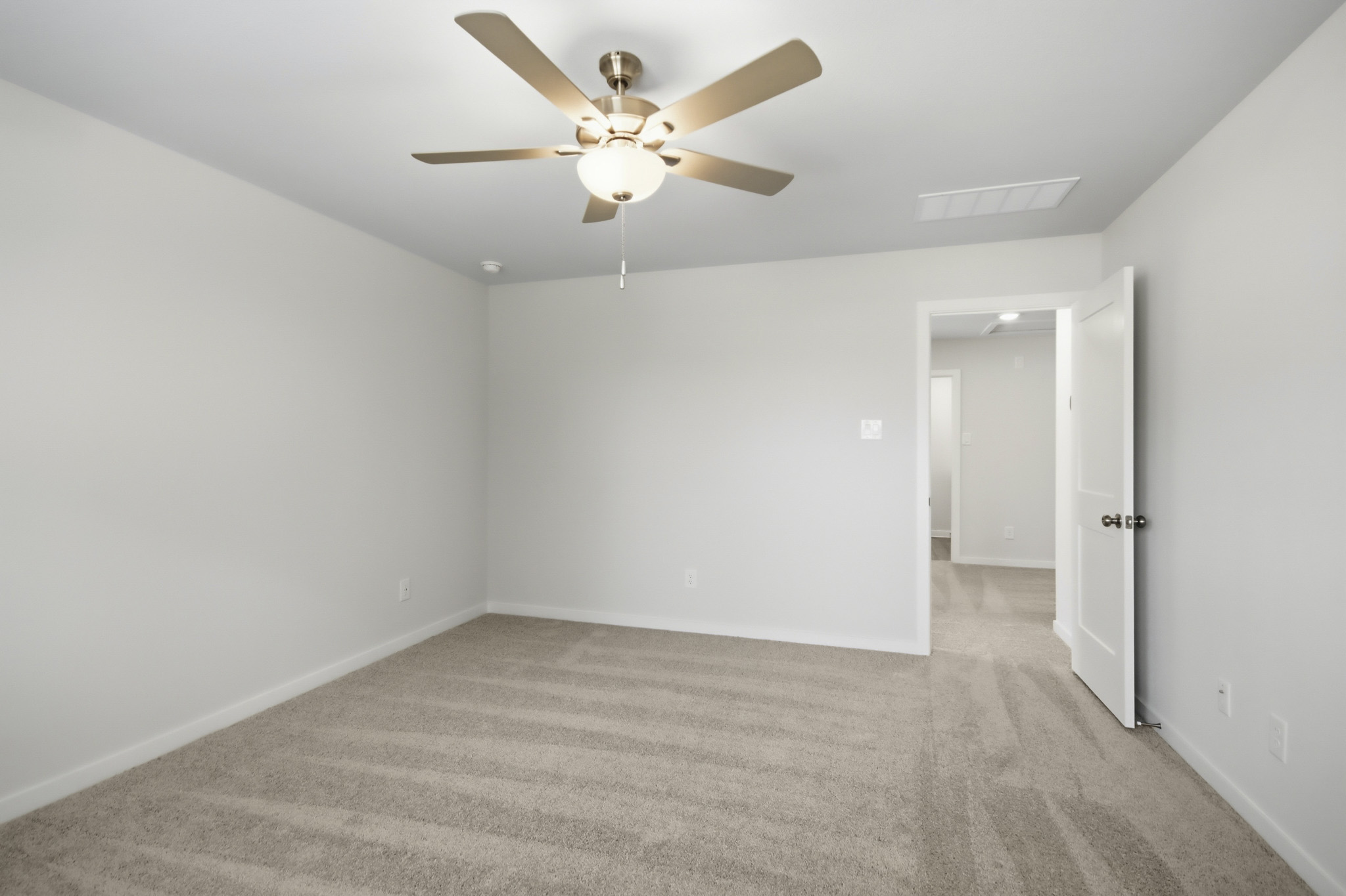 A room with a ceiling fan and a door.