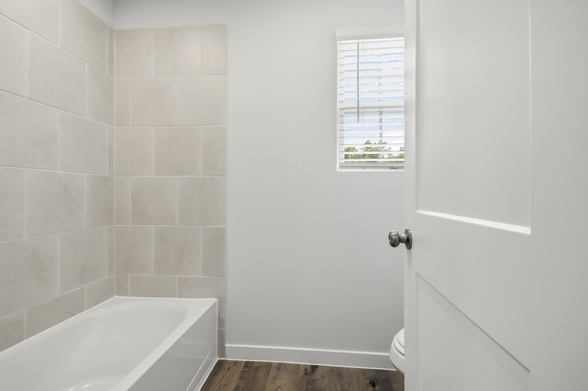 A bathroom with a tub and toilet.