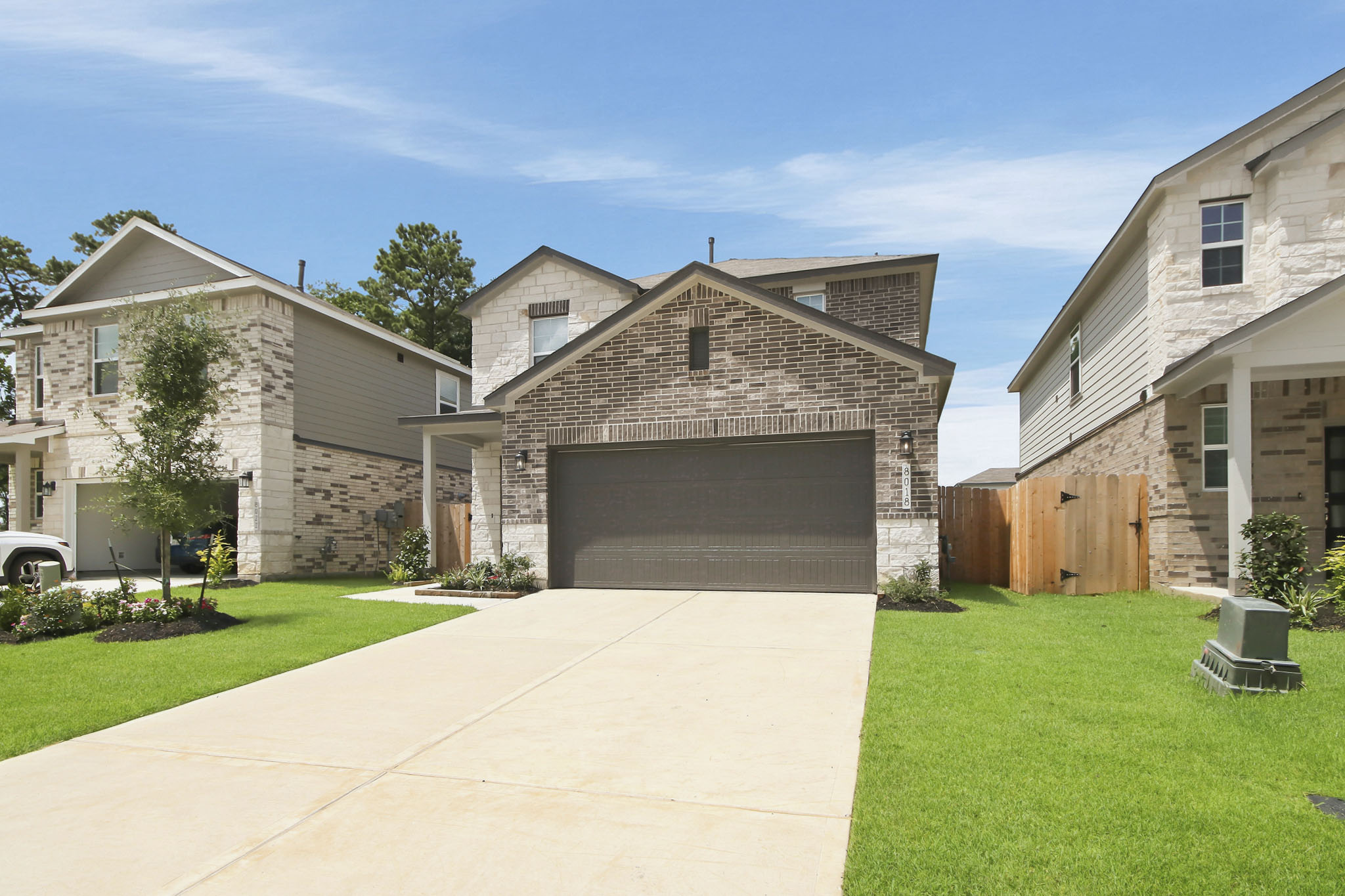 A driveway leading to a house with Chavenage House in the background.