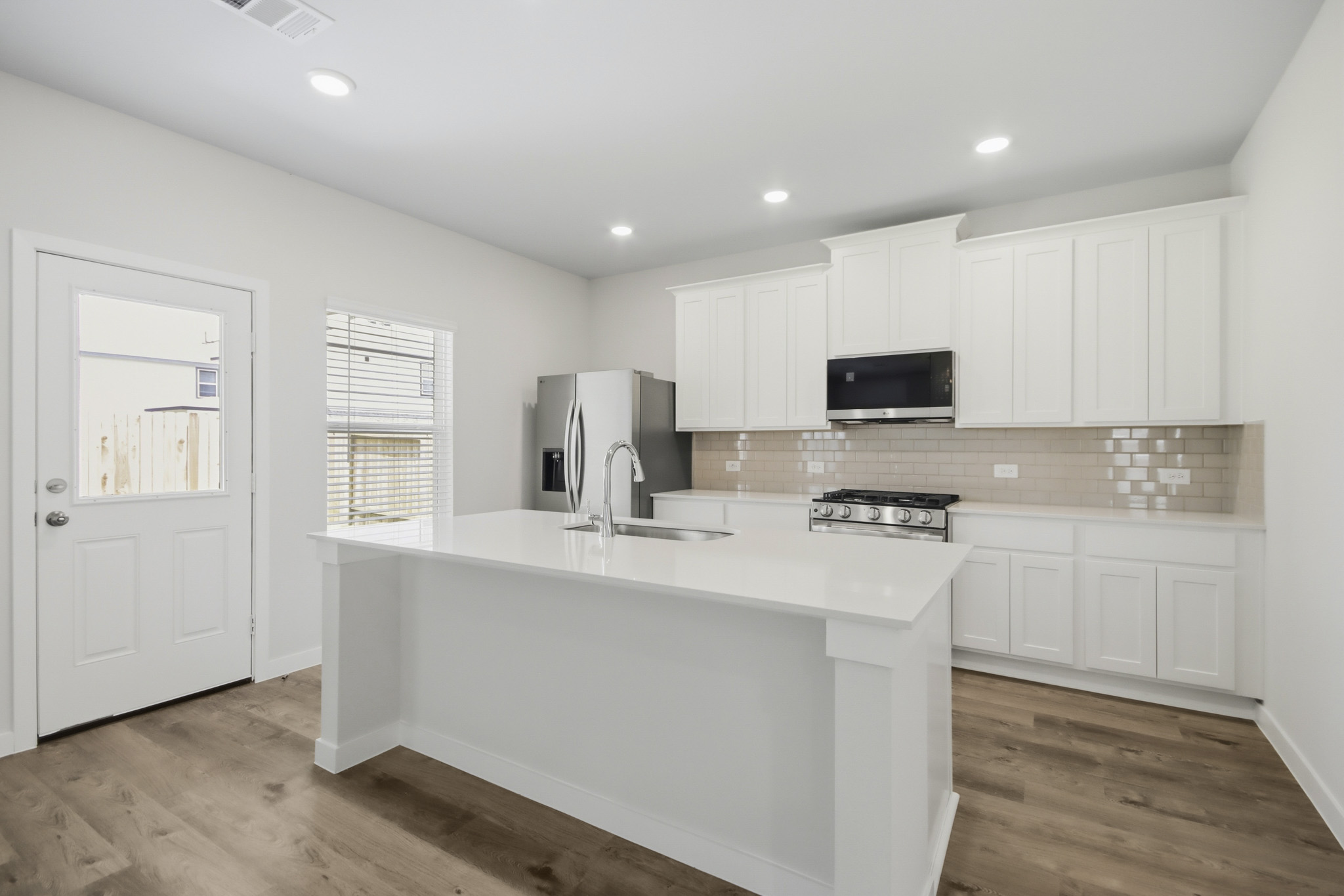A kitchen with white cabinets.