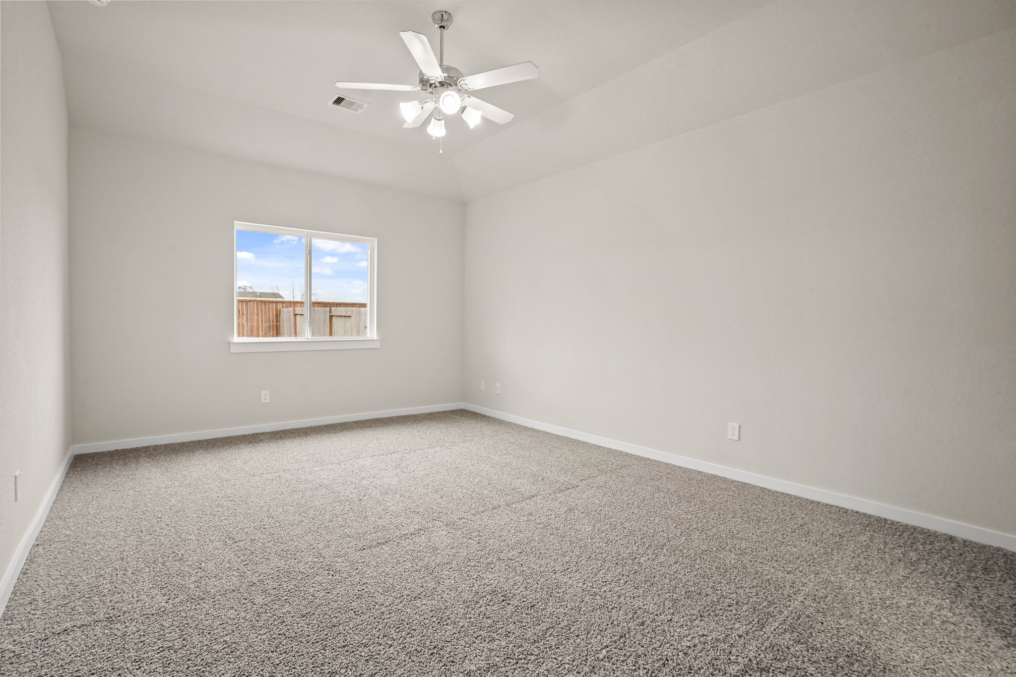 A room with a ceiling fan and a window.