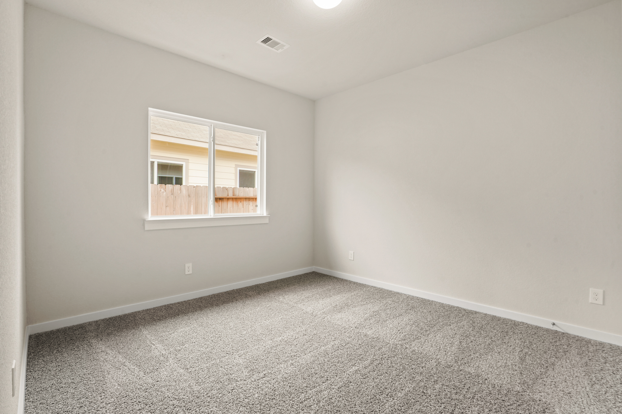 A room with a window and carpet.