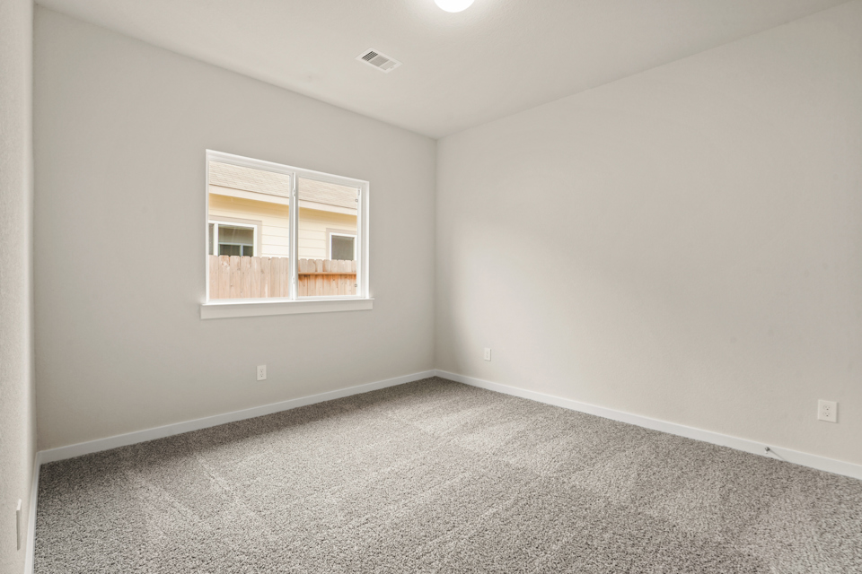 A room with a window and carpet.