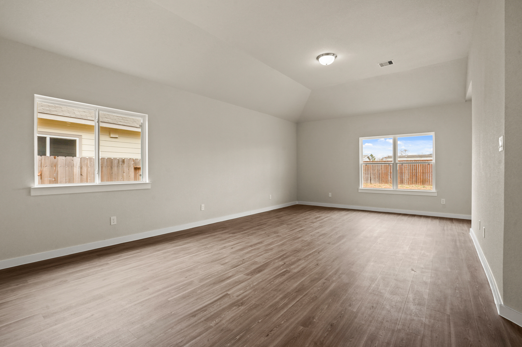 A room with a wood floor and windows.