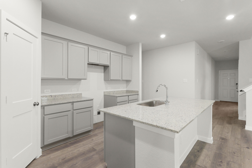 A kitchen with white cabinets.