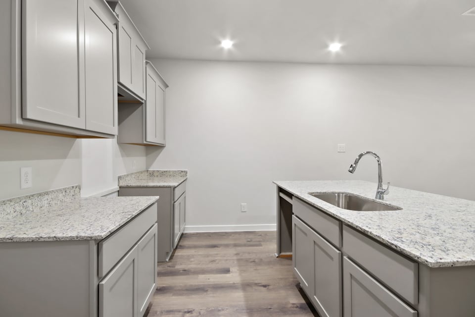 A kitchen with white cabinets.