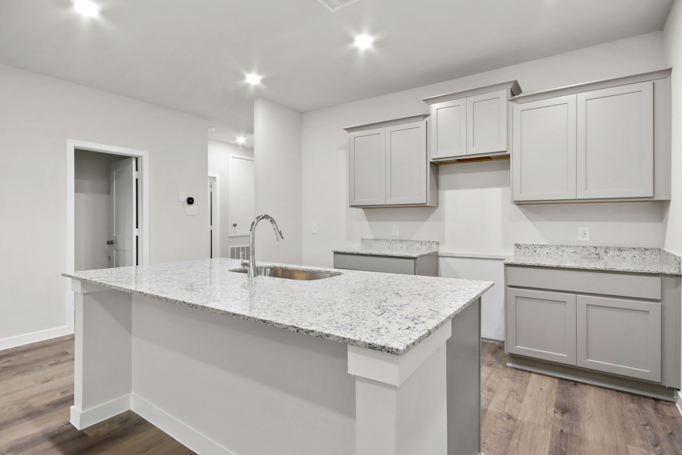 A kitchen with white cabinets.