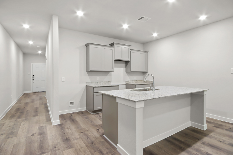 A kitchen with white cabinets.