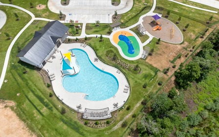 A building with a pool in the middle of a field.