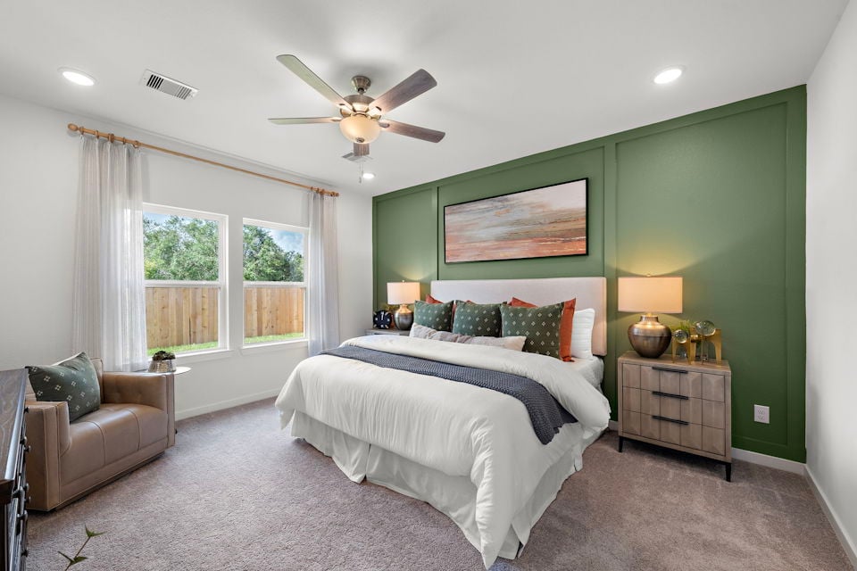 A bedroom with a bed and a fan.