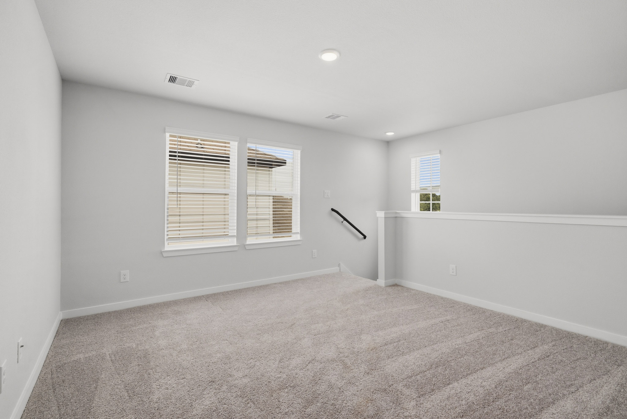 A room with a white wall and a window.