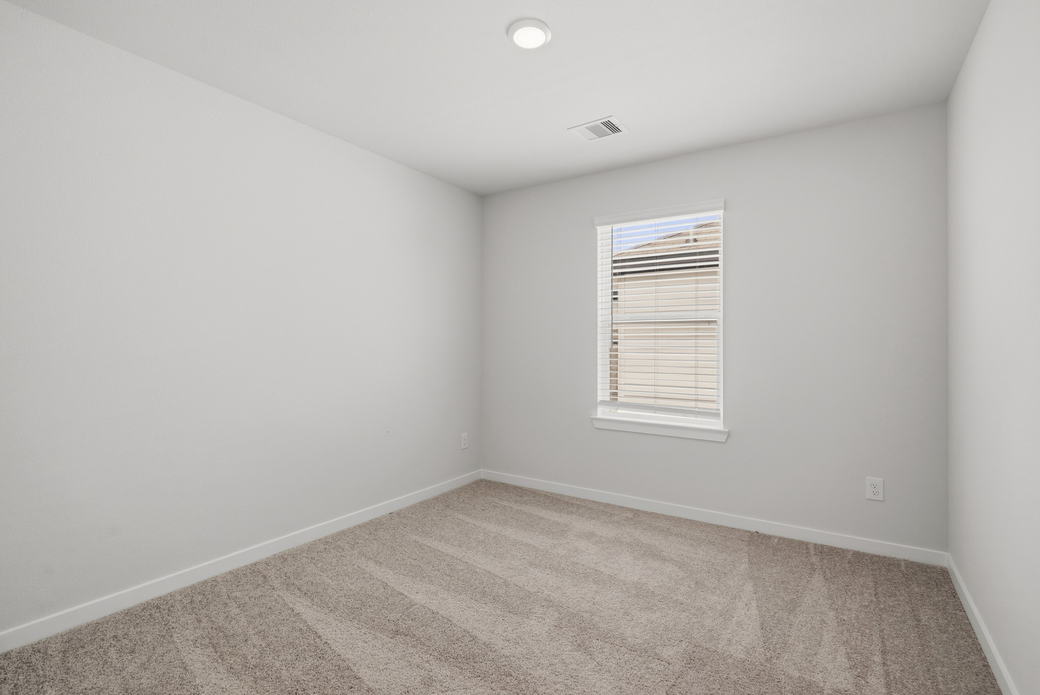 A room with a carpet and a window.