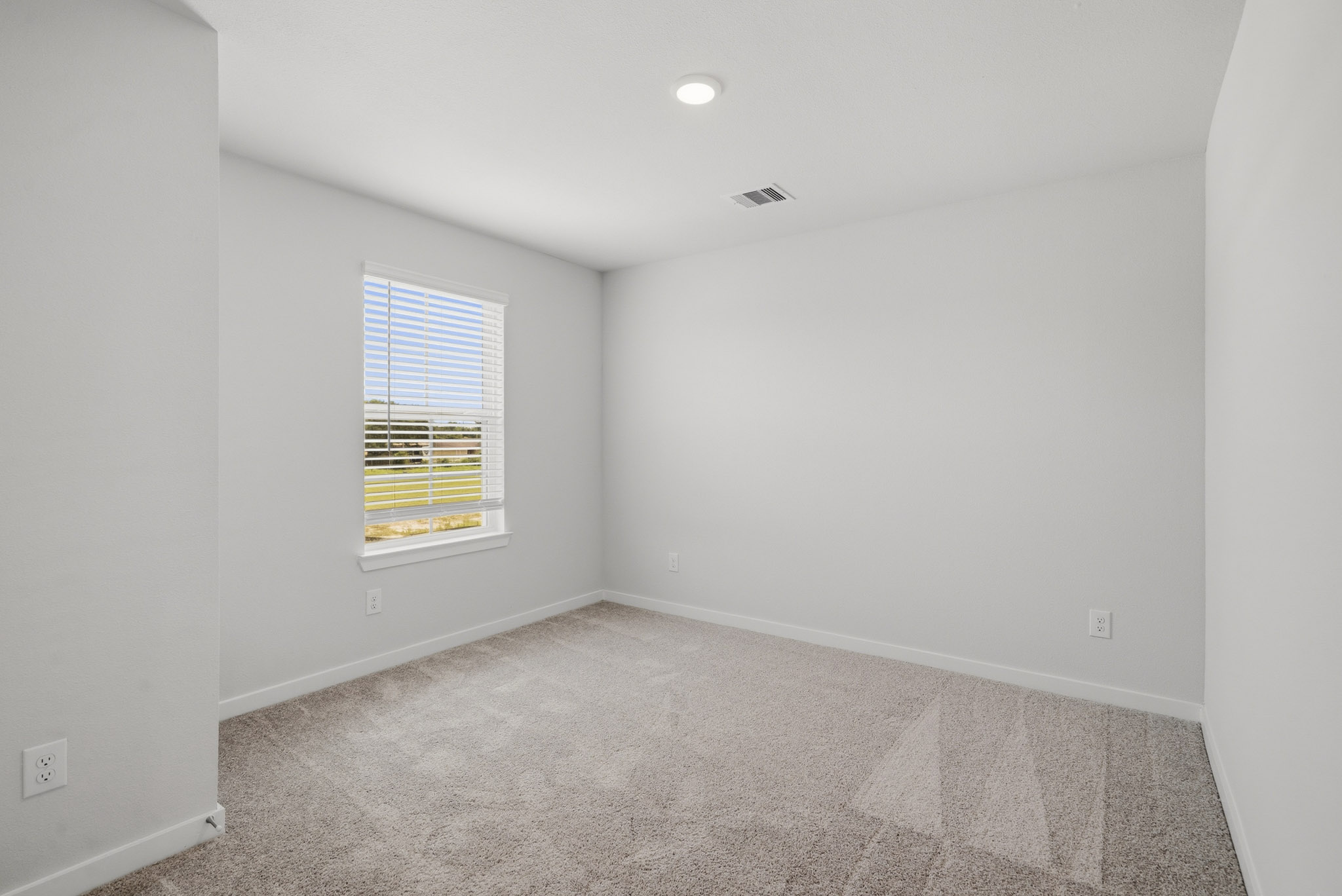 A room with a carpet and a window.