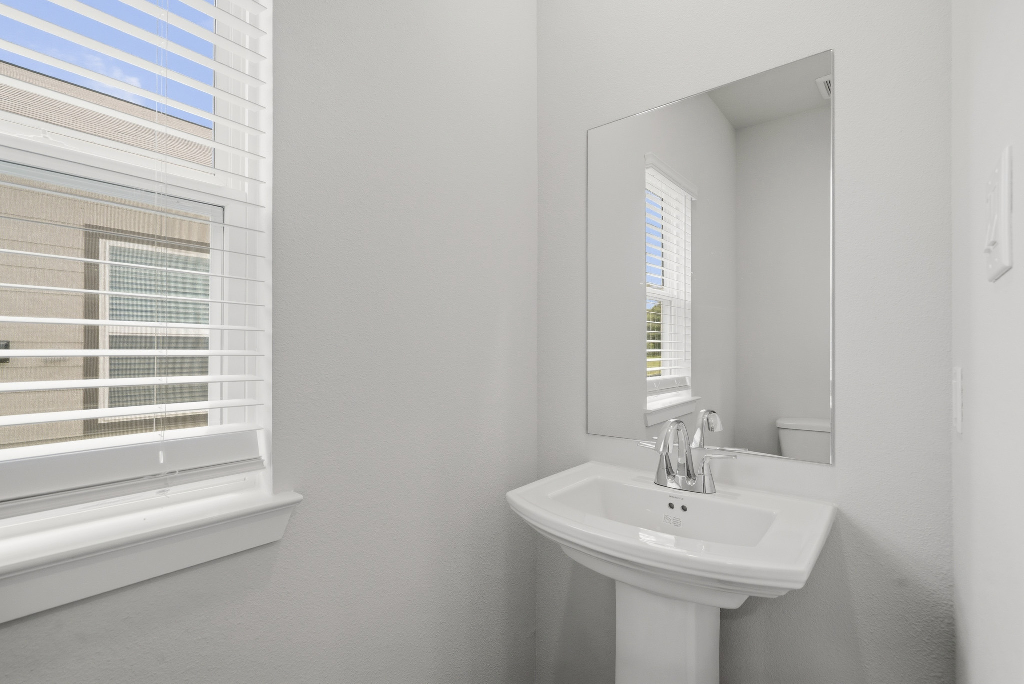 A bathroom with a mirror and sink.