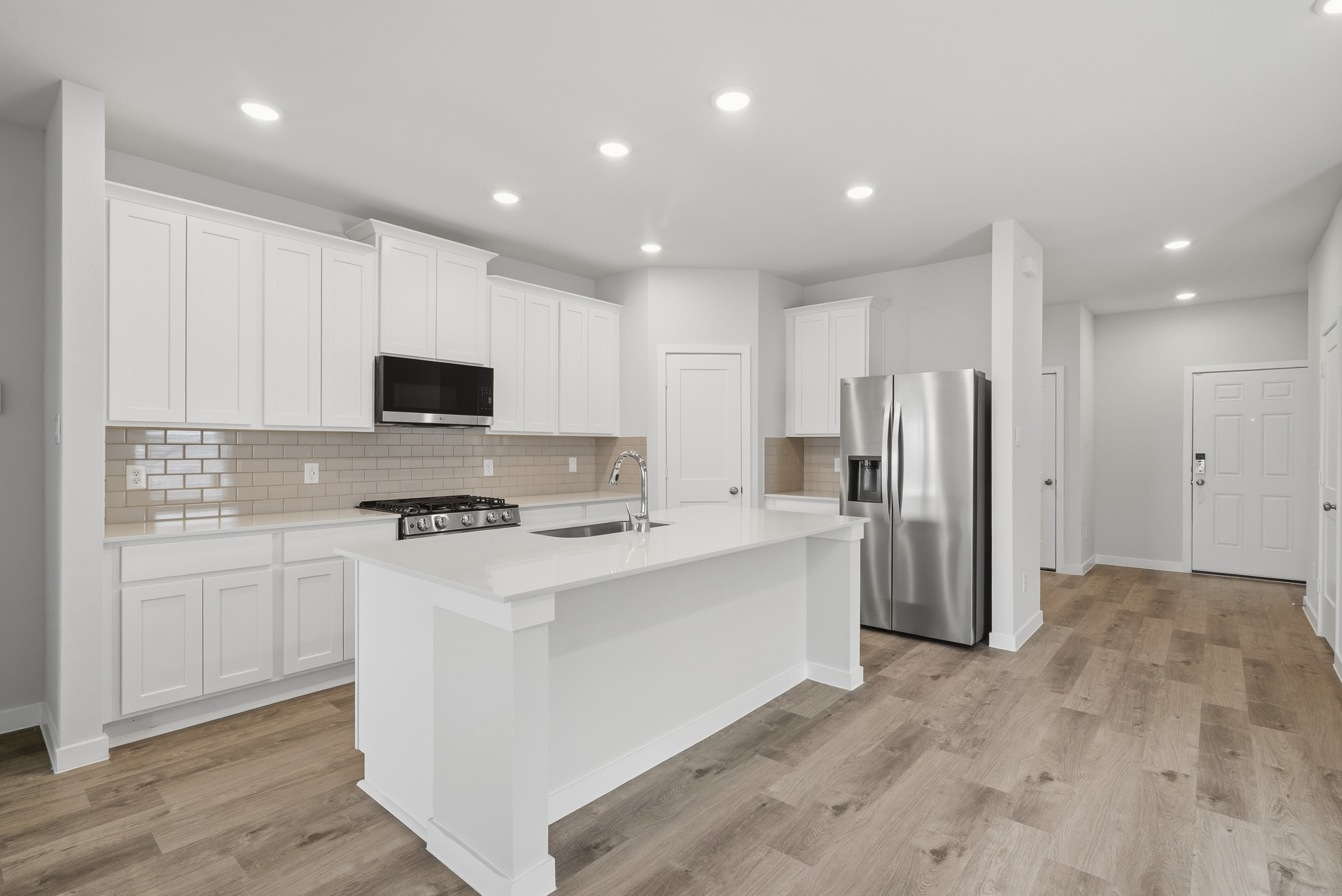 A kitchen with white cabinets.