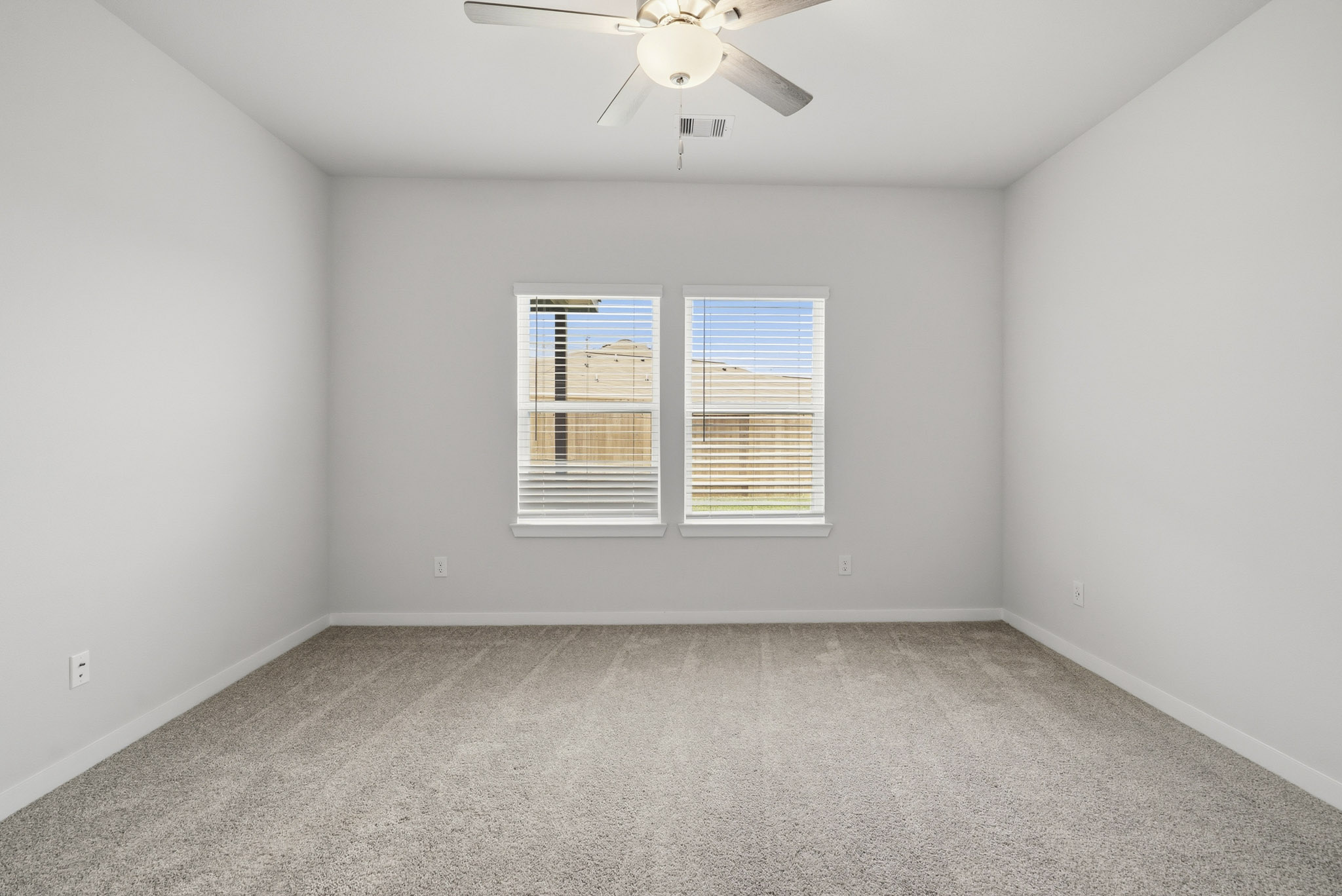 A room with a ceiling fan and a window.