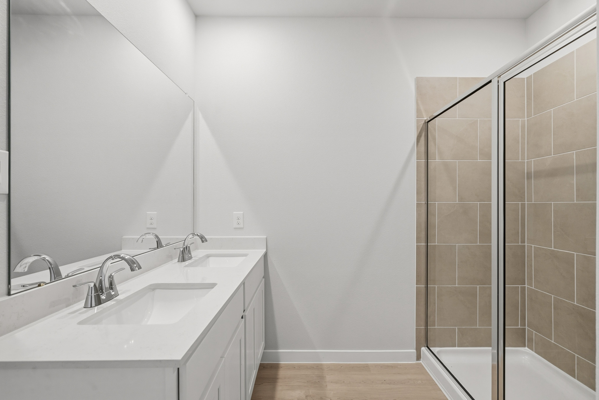 A bathroom with a sink and a shower unit.