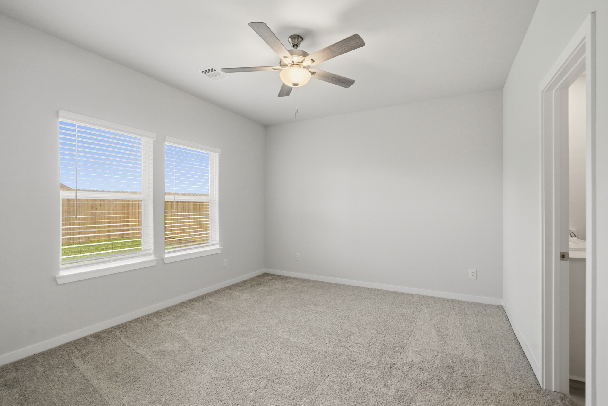 A room with a ceiling fan and a window.