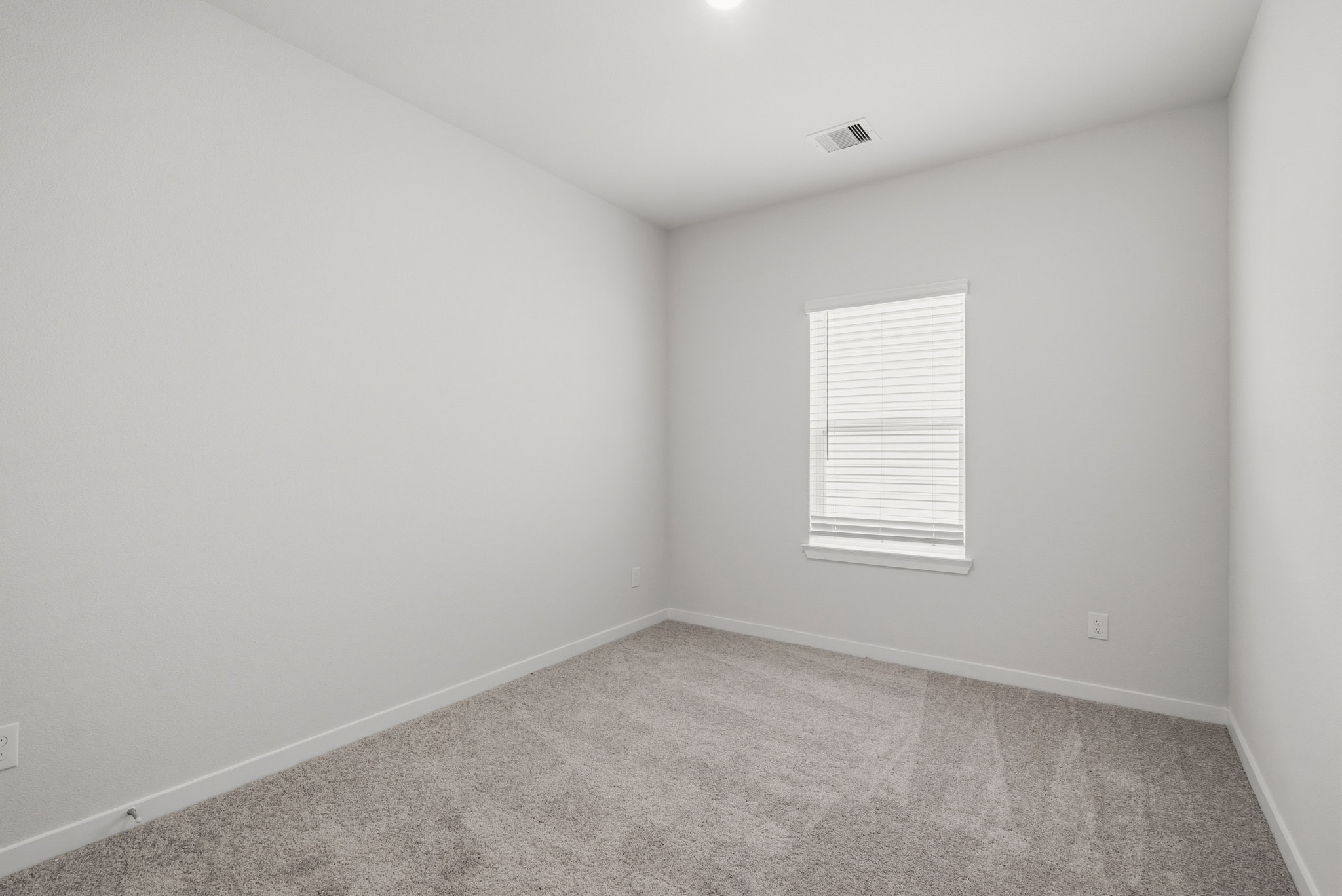 A room with a window and carpet.