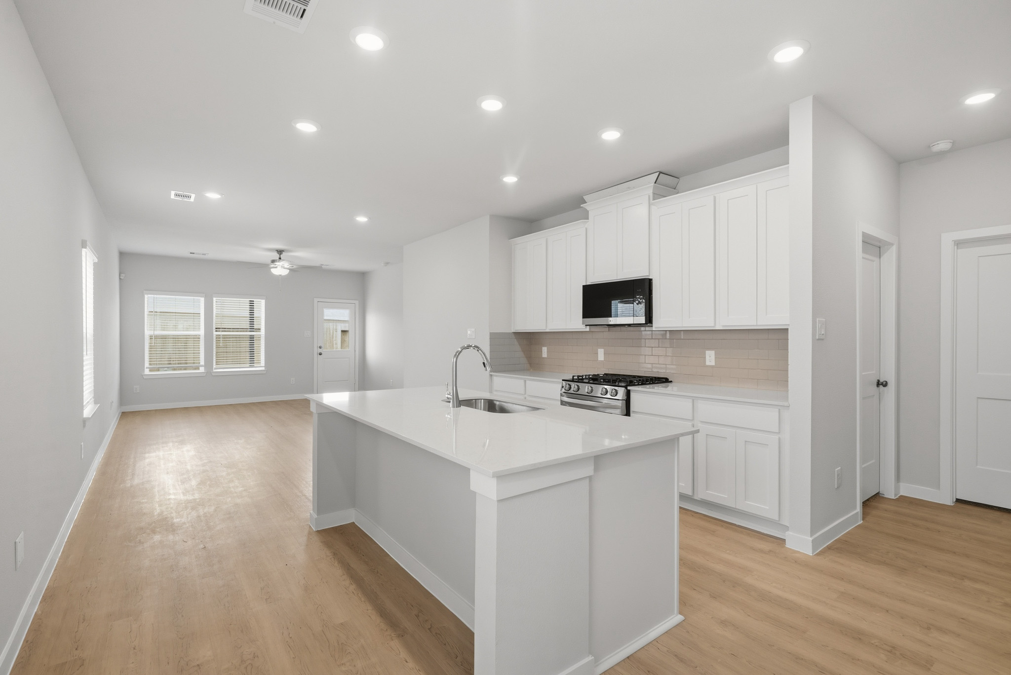 A kitchen with white cabinets.