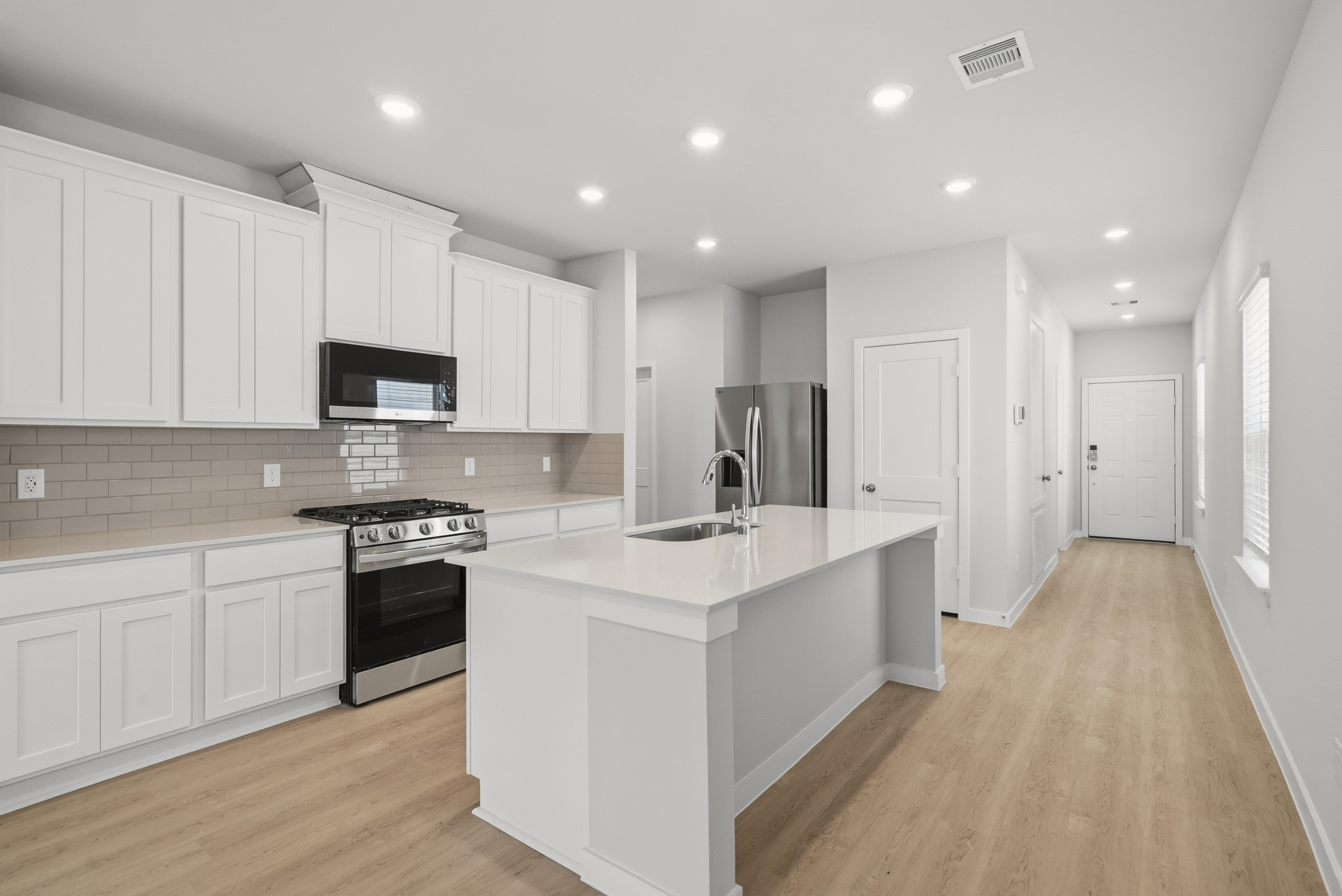 A kitchen with white cabinets.