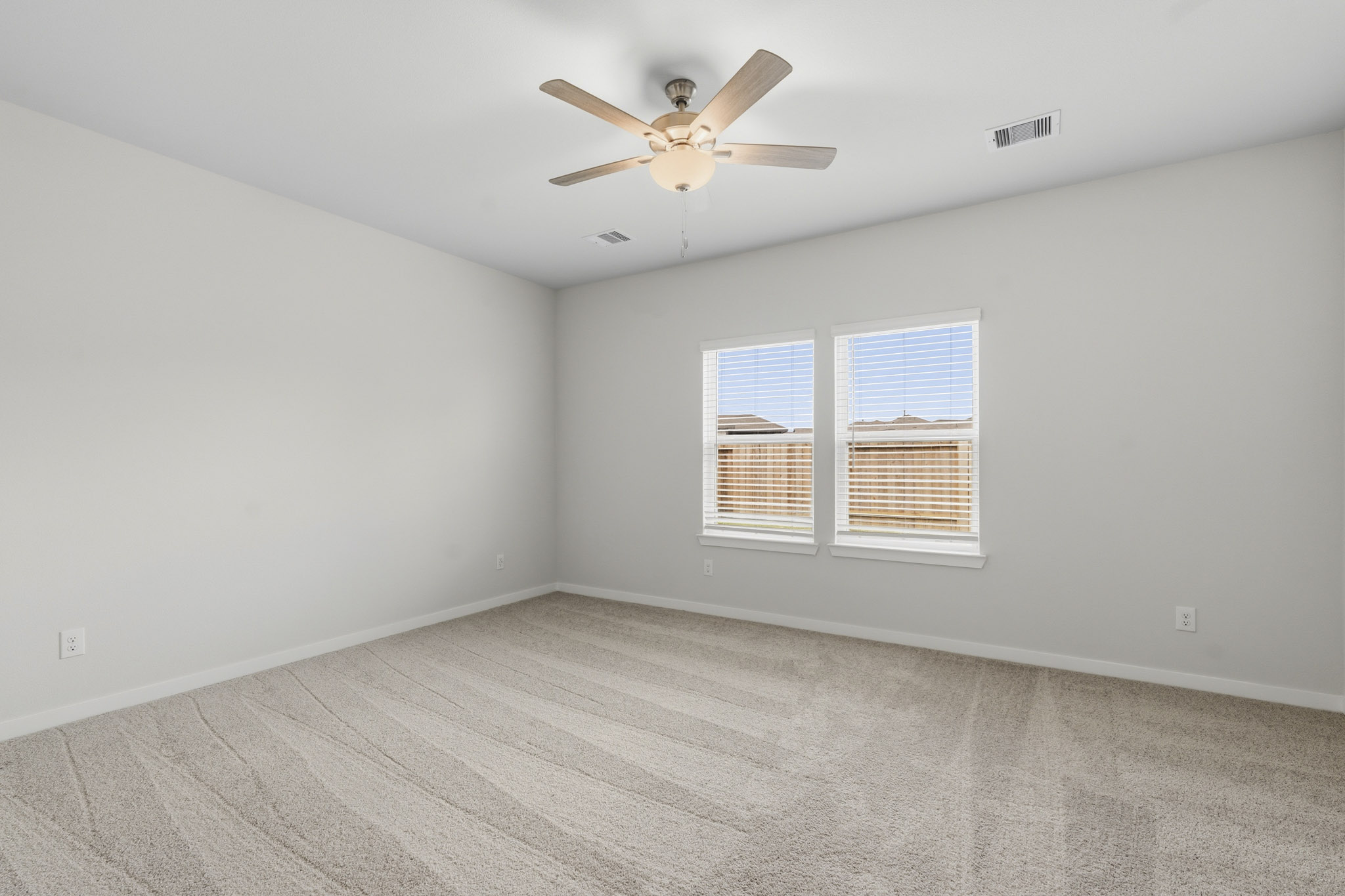 A room with a ceiling fan and a window.