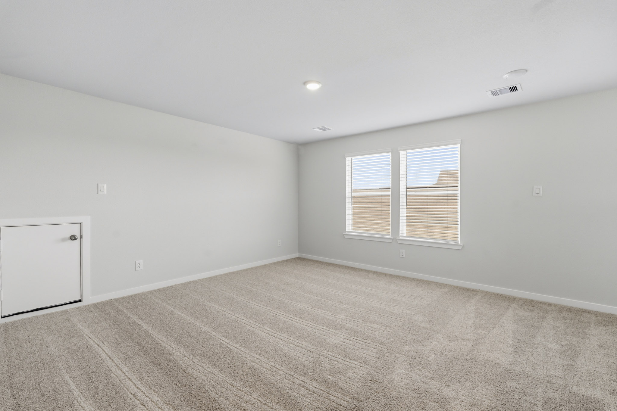 A room with a wood floor and white walls.