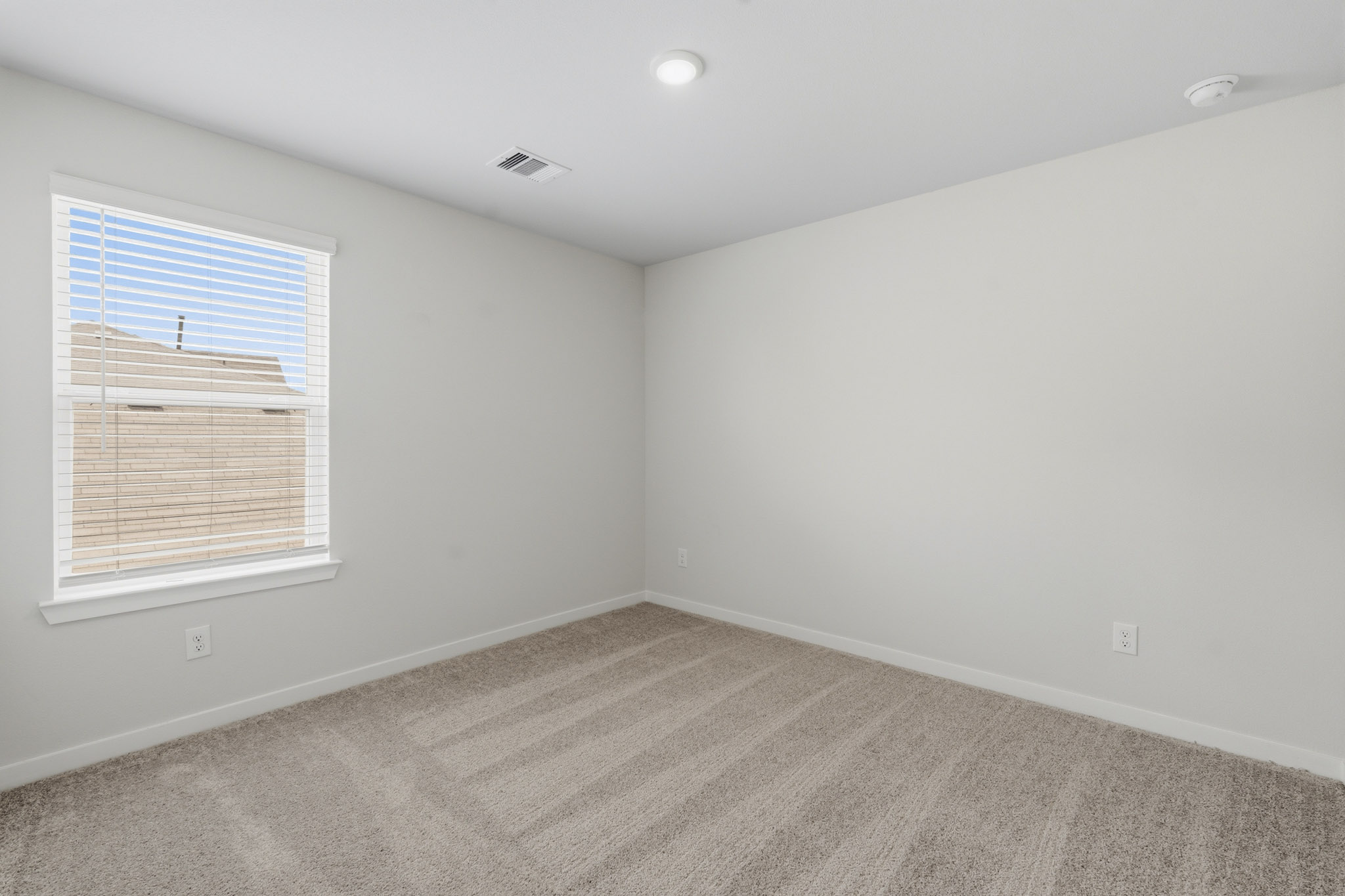 A room with a window and a carpet.