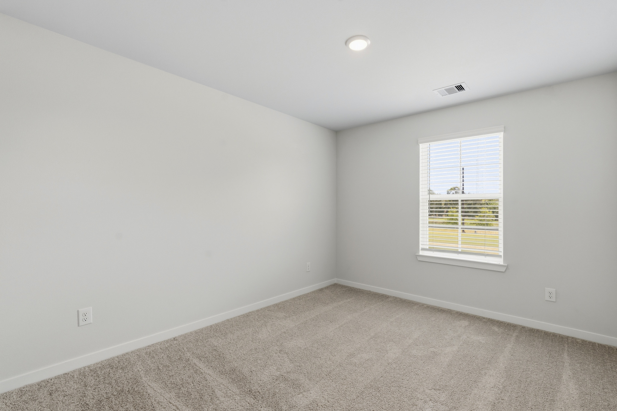 A room with a window and a carpet.