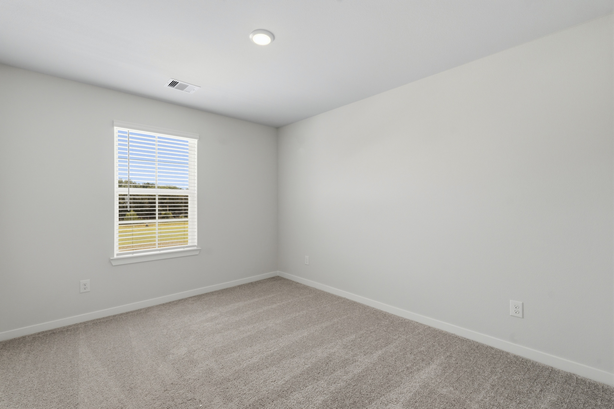 A room with a window and a carpet.