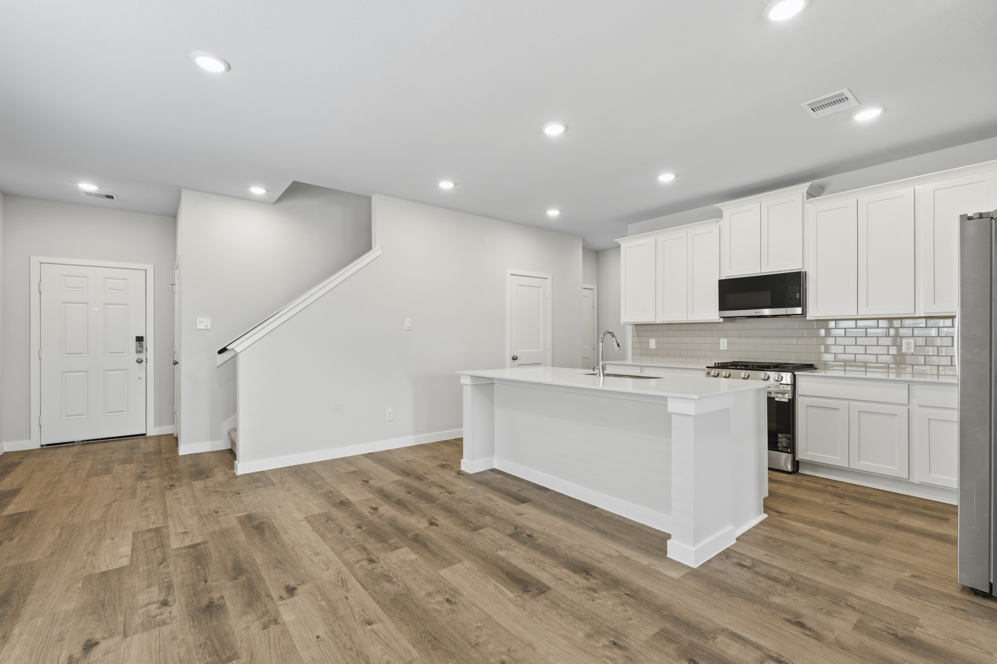 A kitchen with white cabinets.