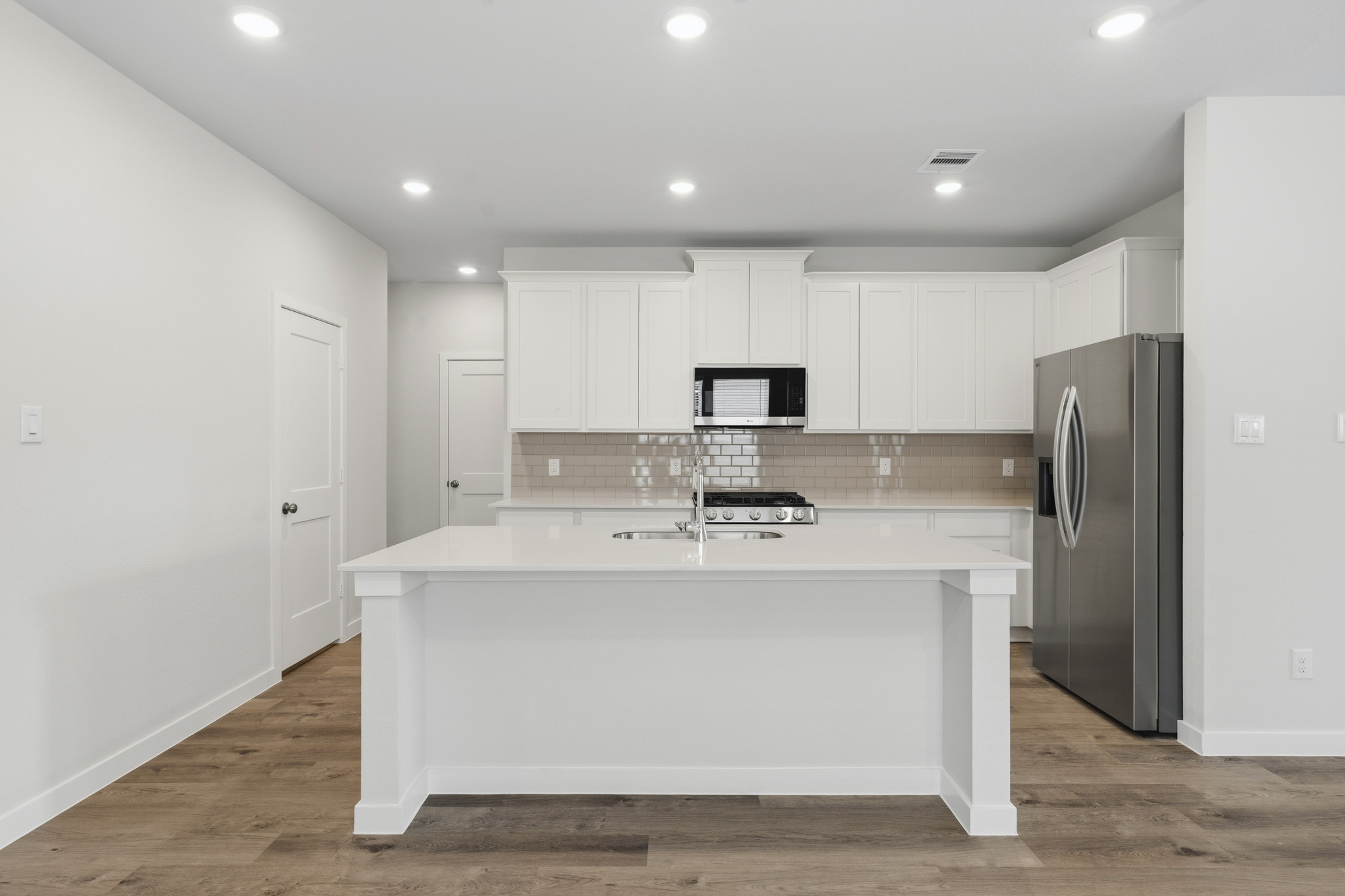 A kitchen with white cabinets.