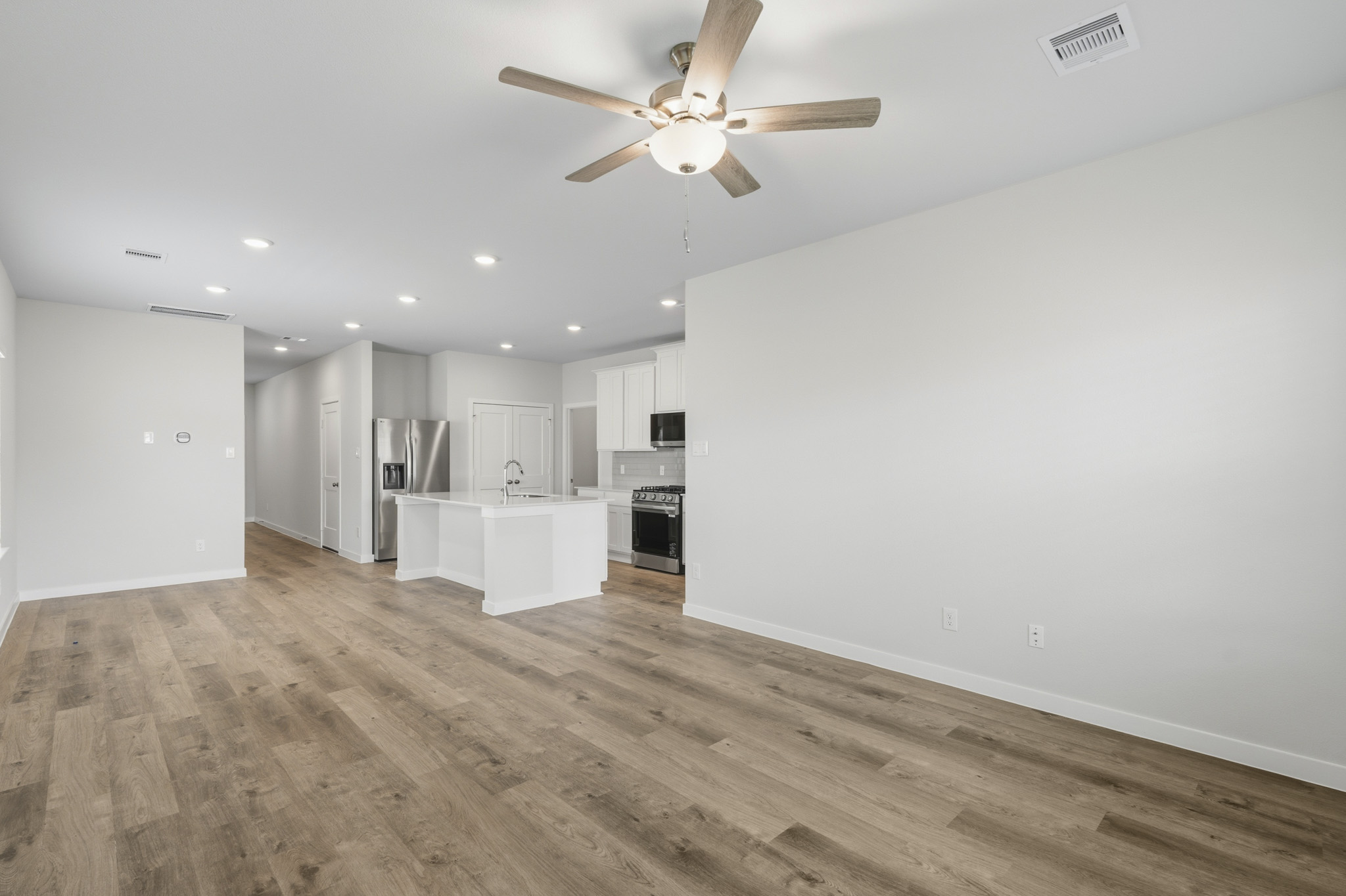 A large kitchen with a ceiling fan.