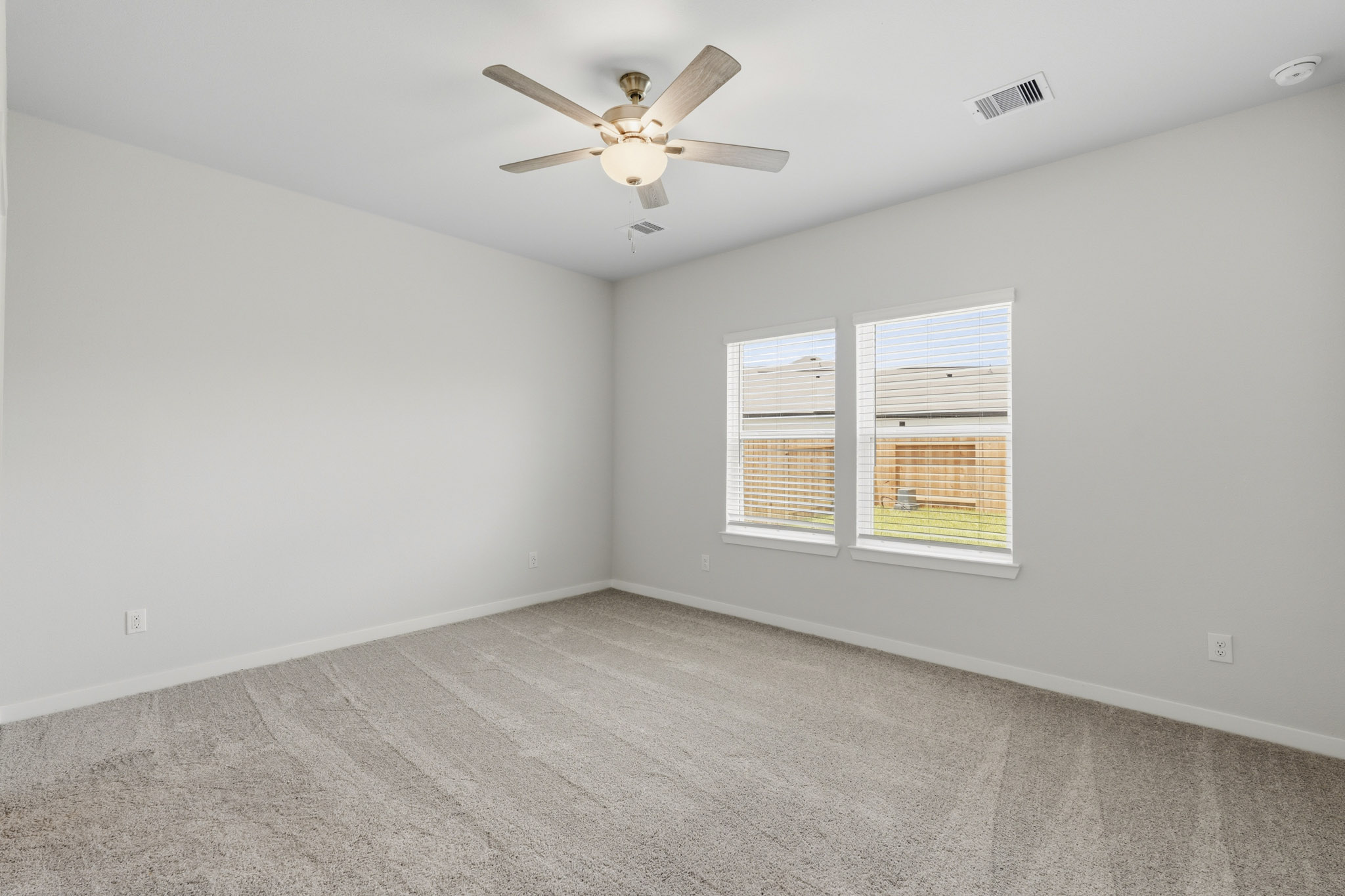 A room with a ceiling fan and a window.