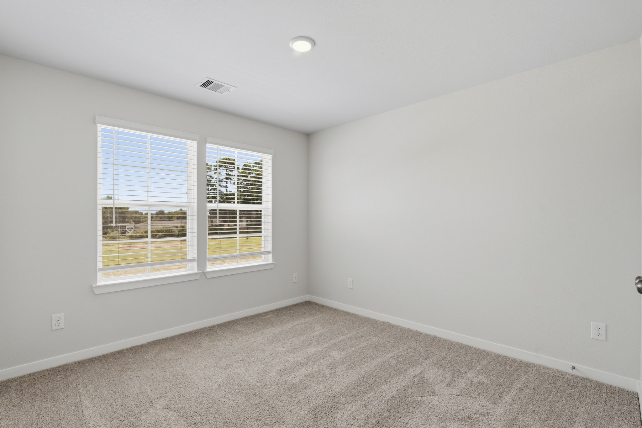 A room with a window and a carpet.