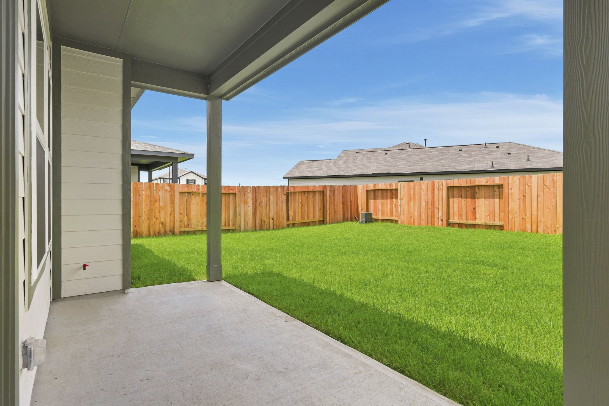 A fenced in yard with a house in the background.