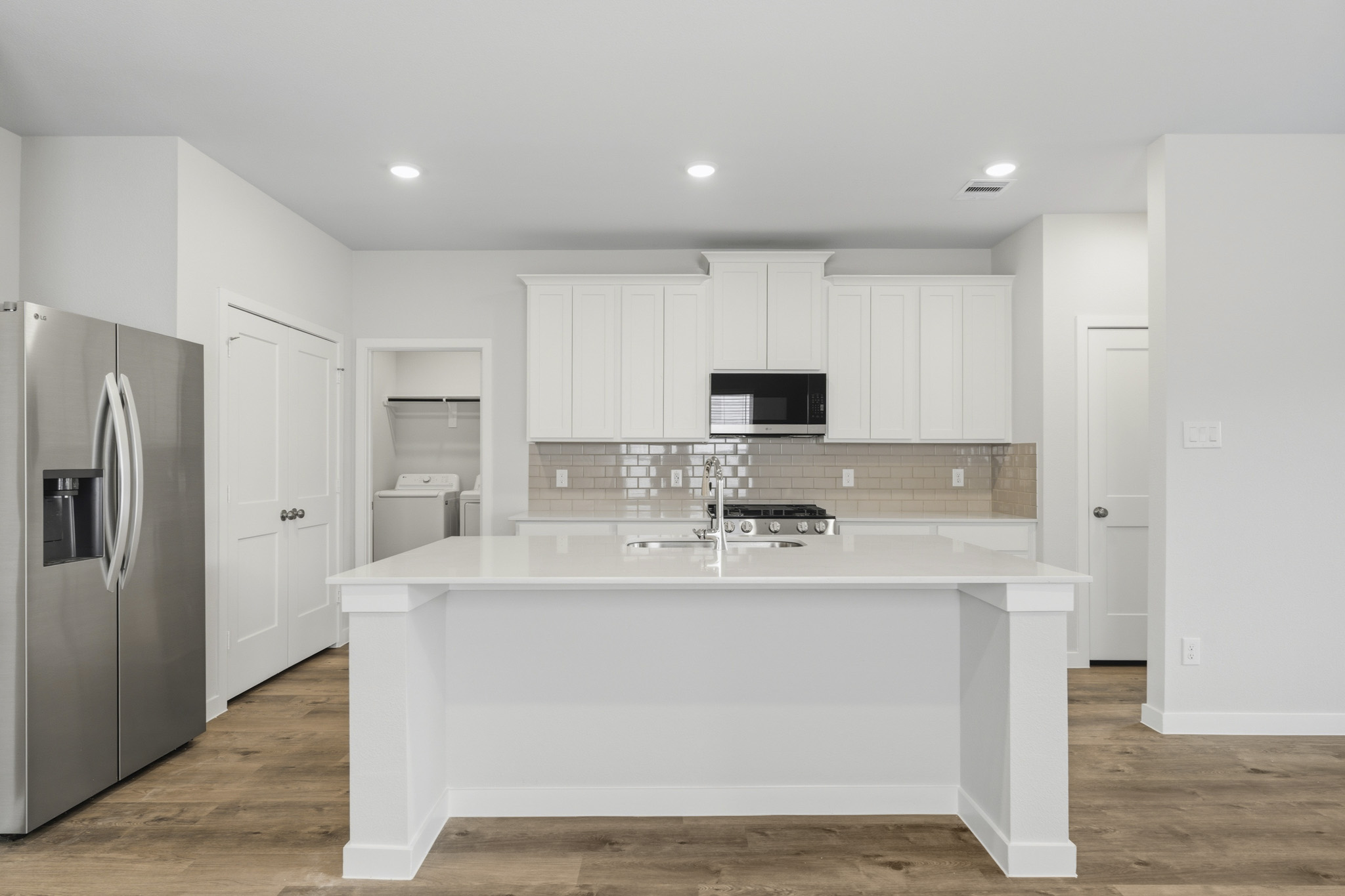 A kitchen with white cabinets.