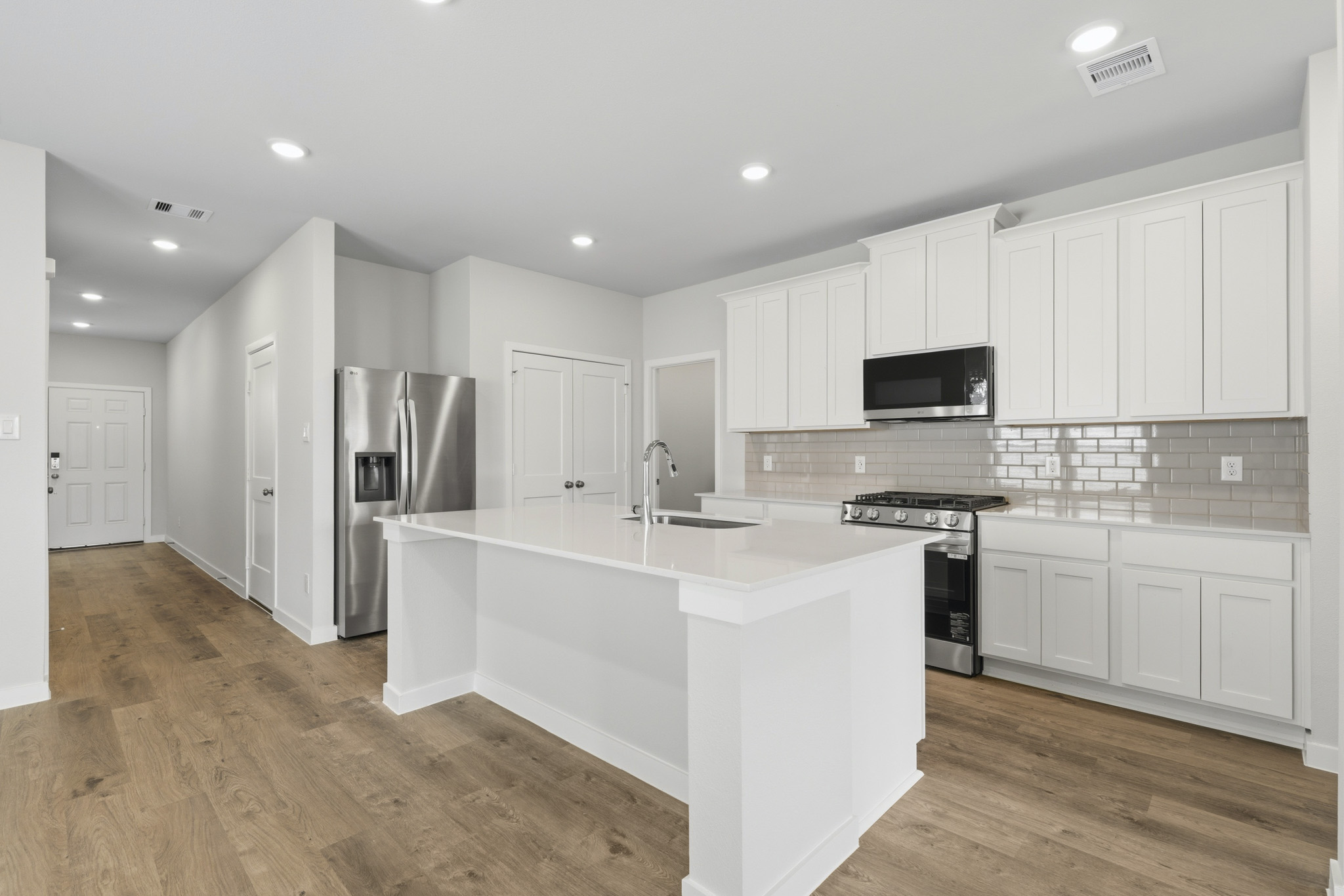 A kitchen with white cabinets.