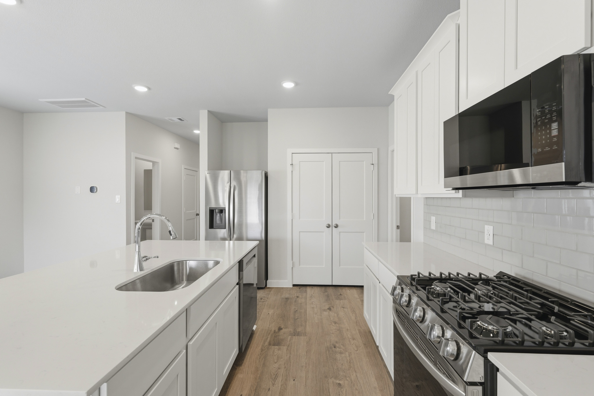 A kitchen with white cabinets.