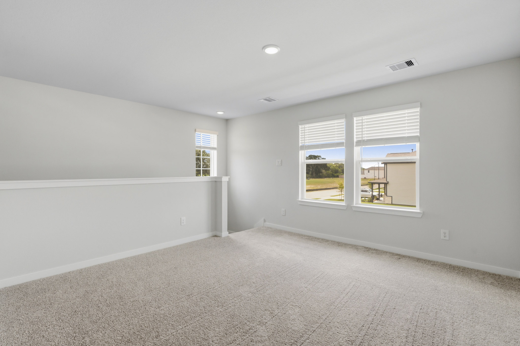 A room with windows and a carpet.